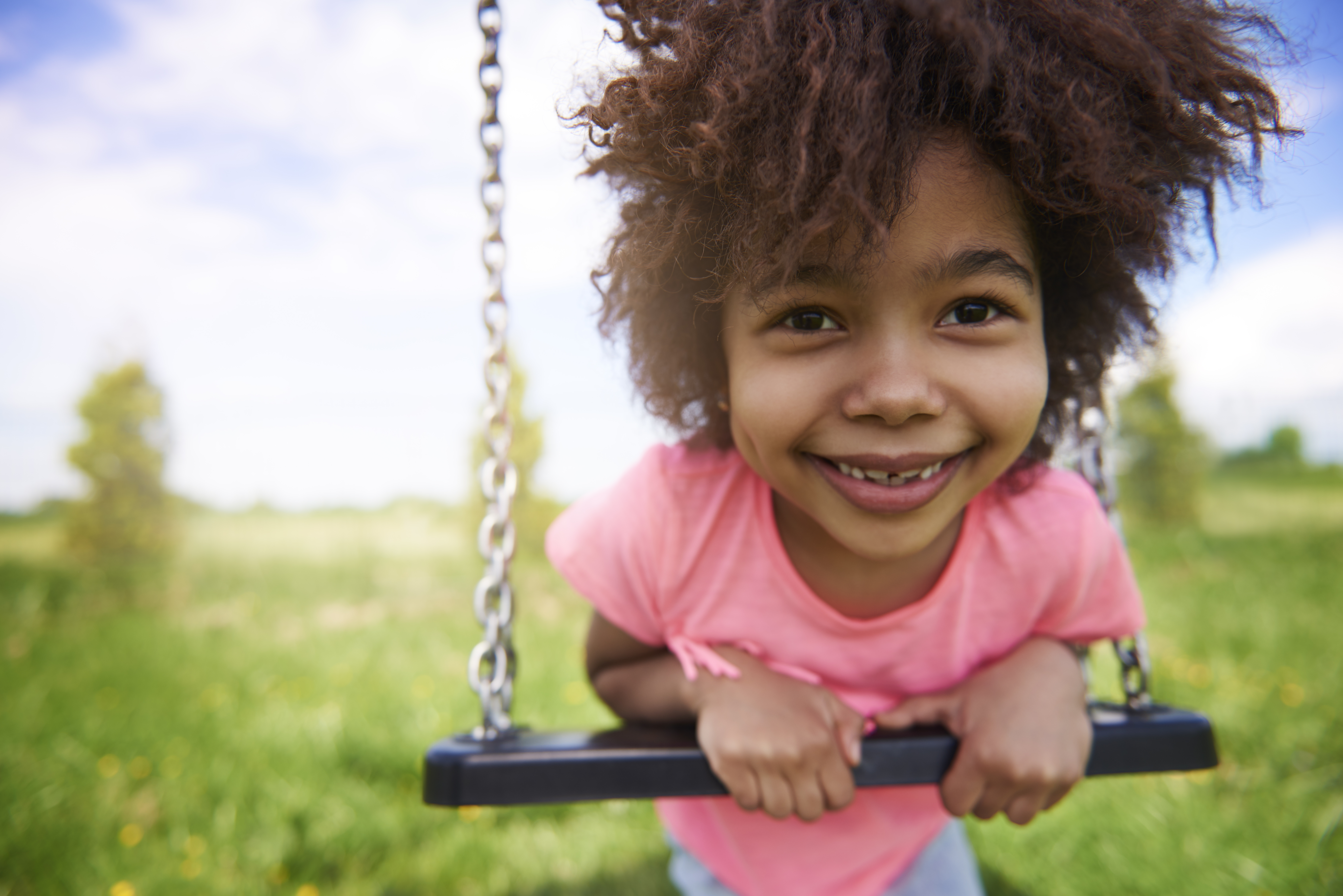 Smiling girl on swing.