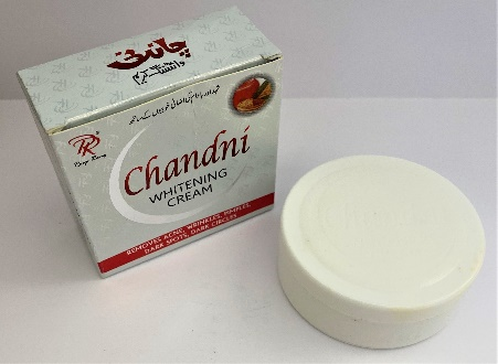 small round white face cream contaner with no labels next to its grey box with red lettering that says Chandni