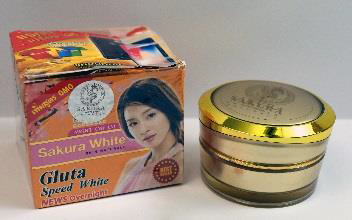 gold round container of face cream next to its orange box with a woman's face in it with red and pink 