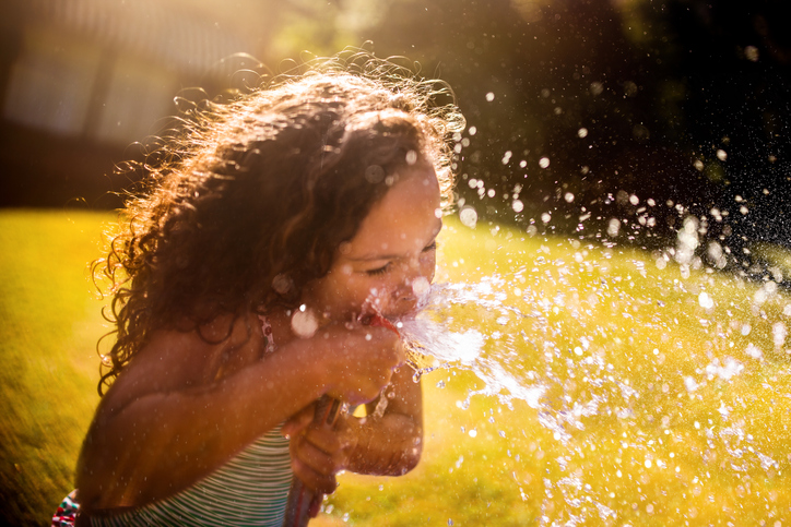 picture of a girl drinking from a water hose