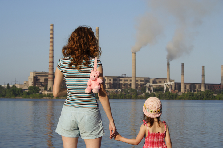 picture of a mother and daughter looking at industry smokestacks