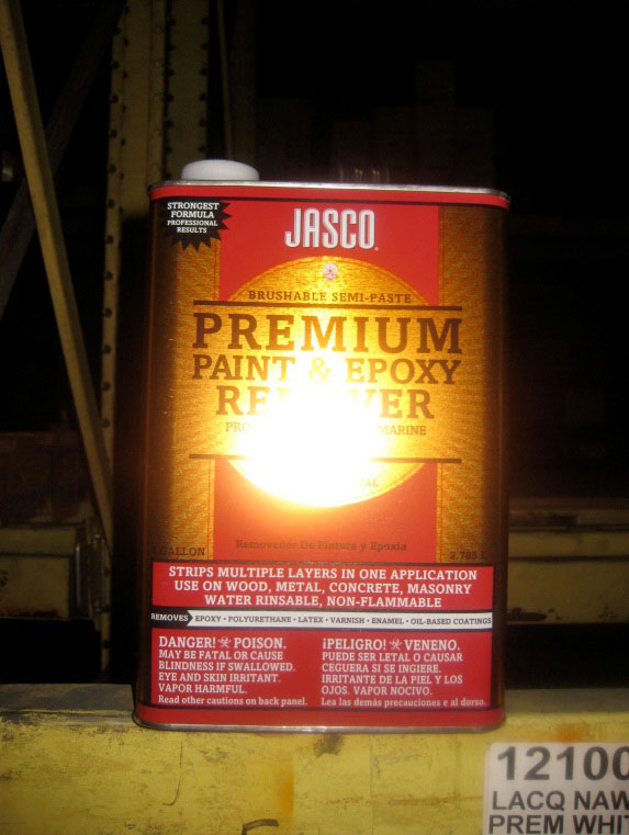 A yellow and gold metal can is labeled Premium Paint and Epoxy Remover. There is a warning on the bottom of the can that says, Danger: Poison.
