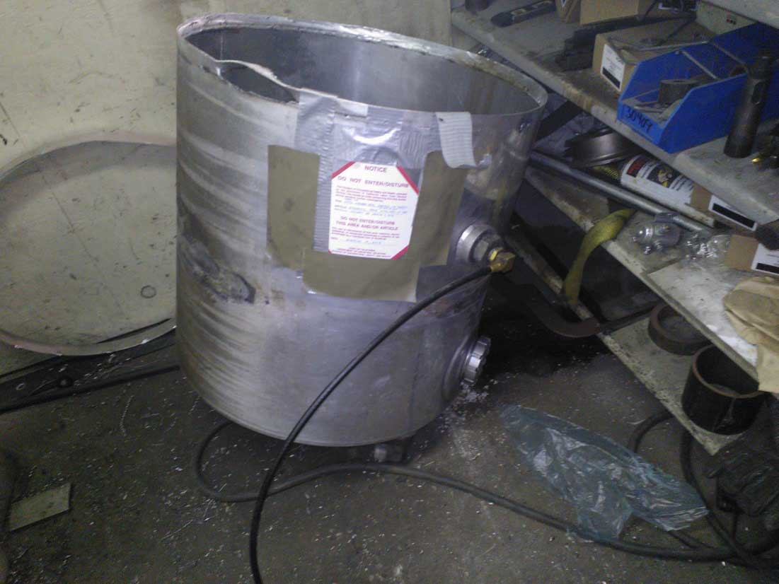 The hydraulic tank involved in the incident. It is open and damaged.