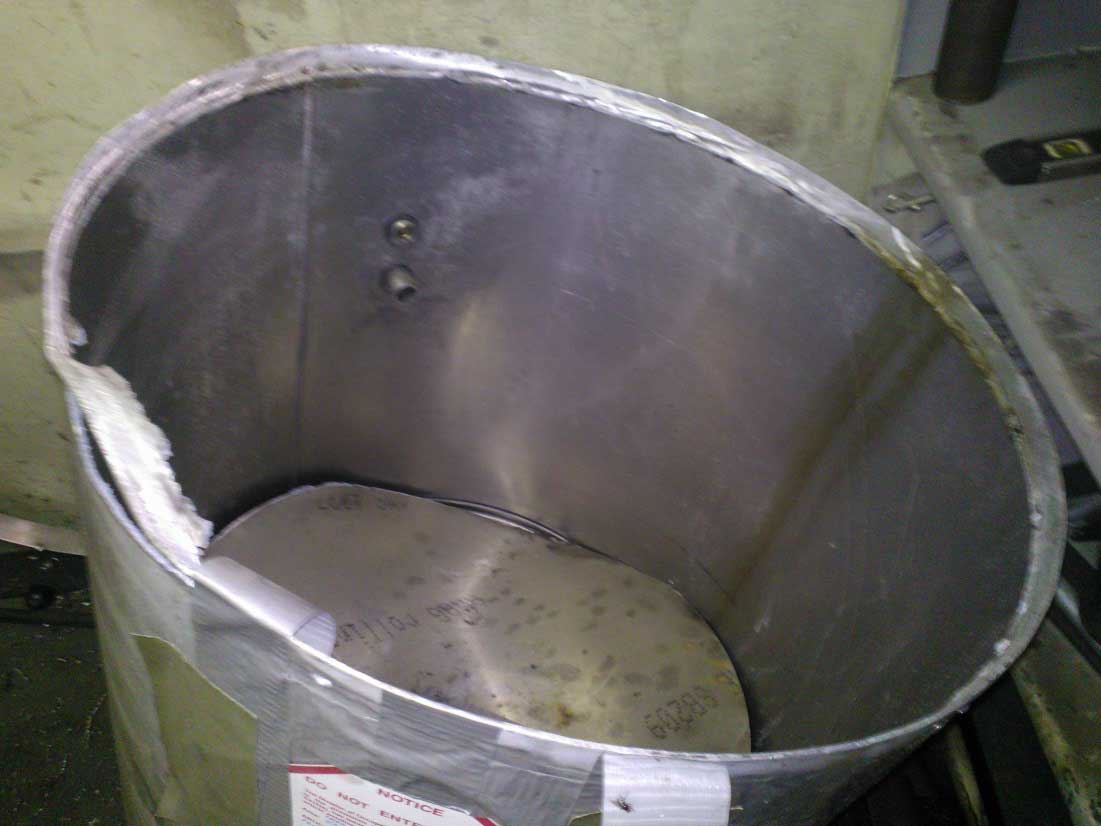 A close-up of the portion of the tank that came off under air pressure. The welded seam is bent and the can is dented.