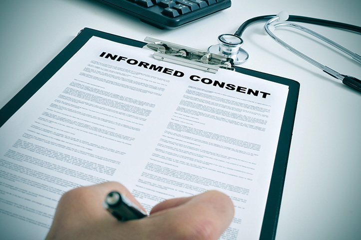 A hand signing an informed consent form