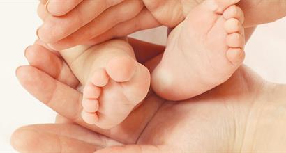 Parent framing infant's feet