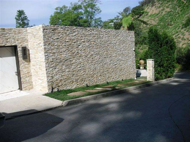 The stone and stucco vertical exterior wall of the home where the incident occurred.